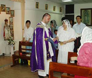 Fr. Pagliarani baptises Mary Magdalene